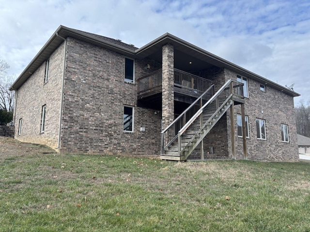 back of property featuring a balcony and a yard