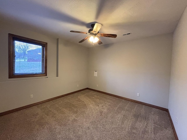 unfurnished room featuring carpet flooring, ceiling fan, and a textured ceiling