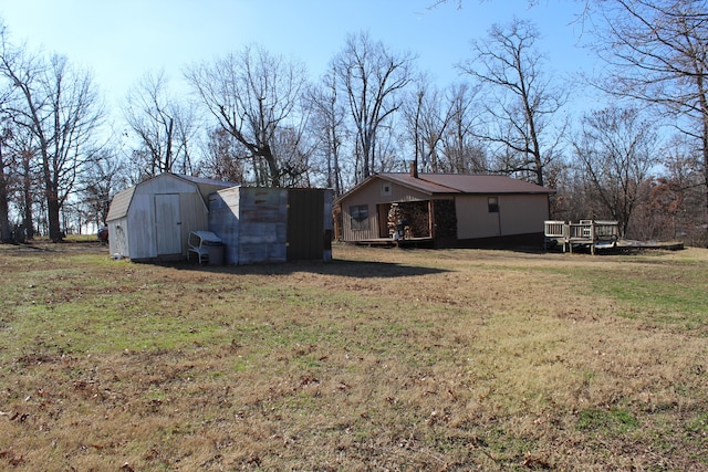 back of house with a shed, a yard, and a wooden deck