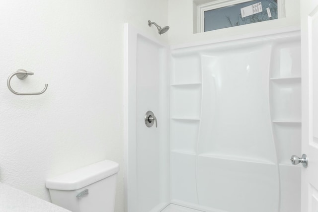 bathroom featuring a shower and toilet