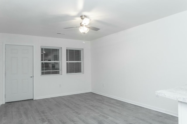 unfurnished room with ceiling fan and hardwood / wood-style floors