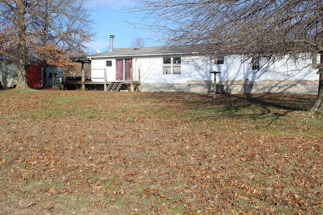 rear view of house featuring a yard