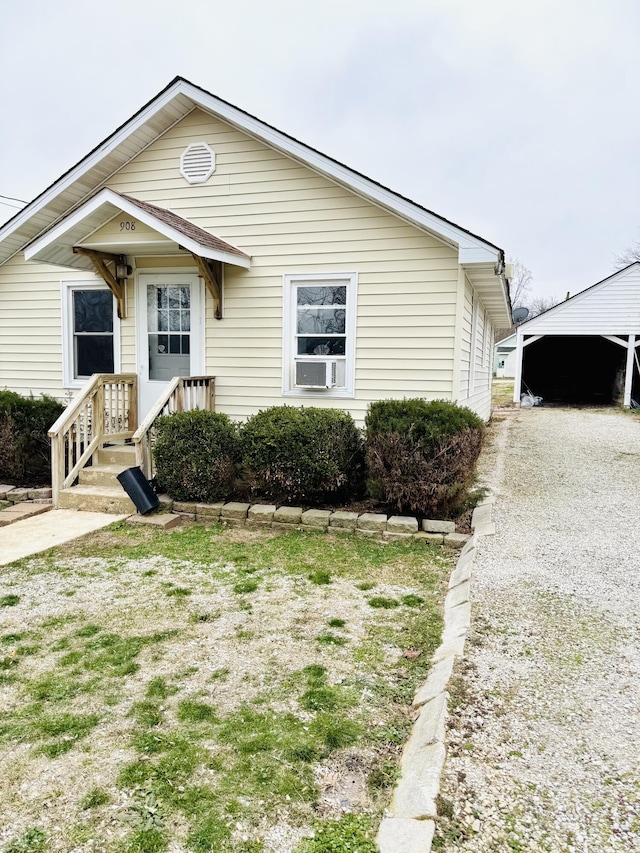 bungalow featuring a garage and an outbuilding