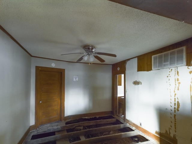 stairway featuring ceiling fan, crown molding, and a textured ceiling