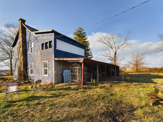 view of side of property featuring a sunroom and a yard