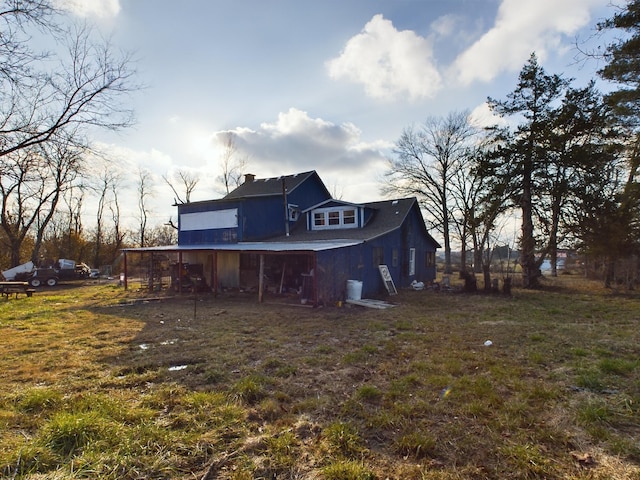 rear view of house featuring a yard