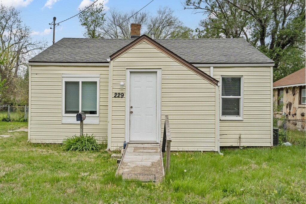 229 N Scenic Ave, Springfield, MO 65802 - exterior space with fence, a front lawn, a chimney, and roof with shingles