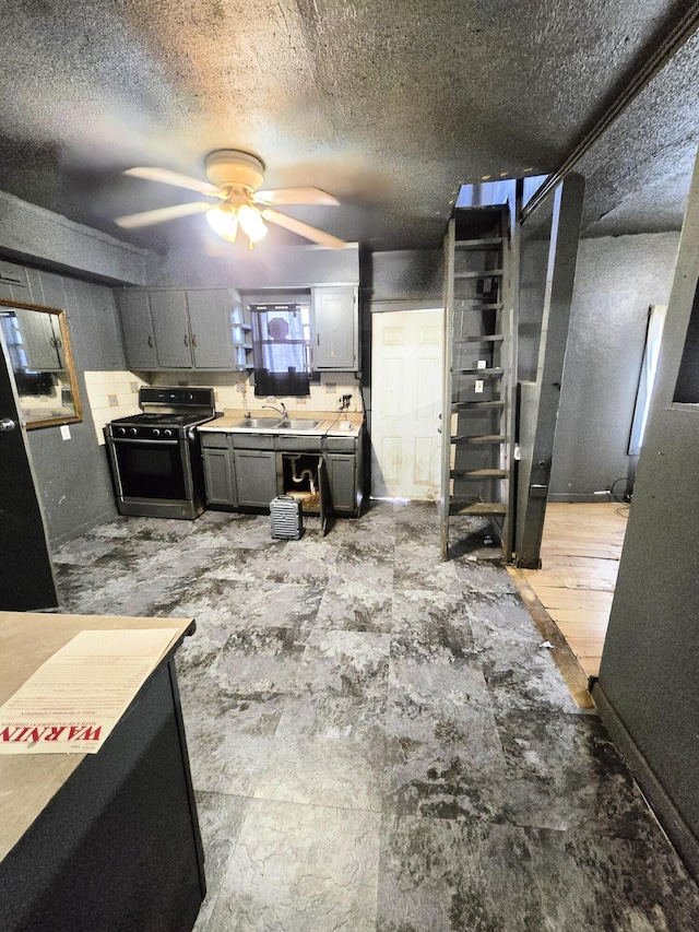 basement featuring a textured ceiling, ceiling fan, and sink