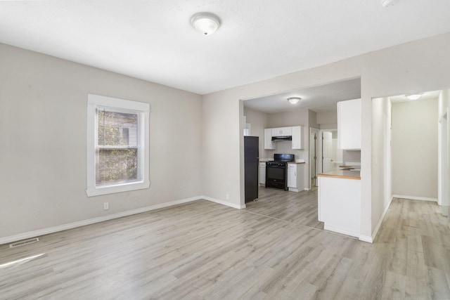 kitchen with black appliances, light wood-type flooring, white cabinetry, and wooden counters