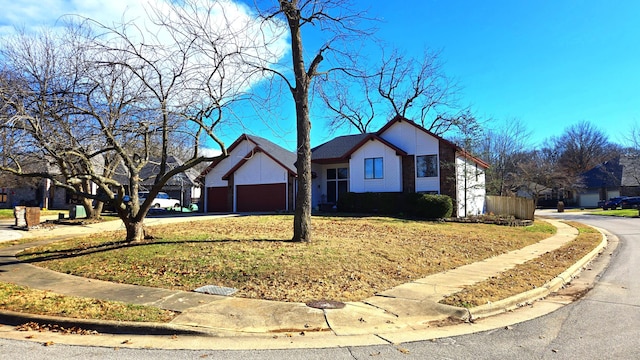 ranch-style house featuring a garage and a front lawn