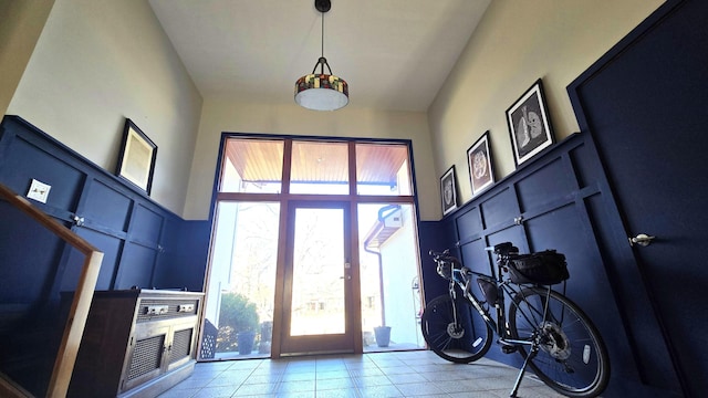 foyer featuring a towering ceiling and light tile patterned flooring