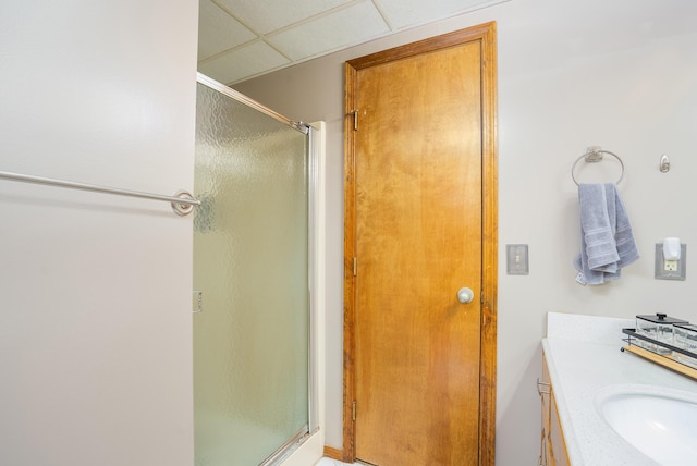 bathroom with vanity, a drop ceiling, and walk in shower