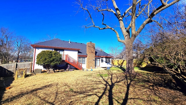 rear view of house with a yard and central AC unit