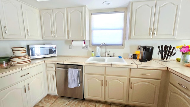 kitchen featuring light tile patterned floors, sink, and appliances with stainless steel finishes