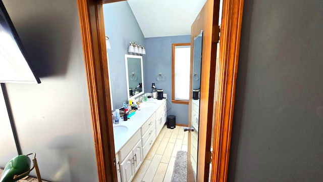 bathroom with vanity, vaulted ceiling, and hardwood / wood-style flooring