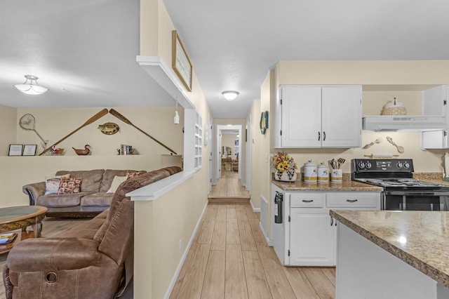 kitchen featuring light wood-type flooring, white cabinetry, and black electric range oven