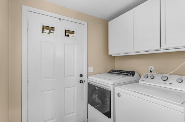 clothes washing area with cabinets and separate washer and dryer