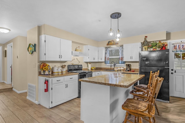 kitchen with ventilation hood, black appliances, pendant lighting, white cabinetry, and a kitchen island