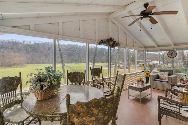 sunroom / solarium with lofted ceiling with beams, plenty of natural light, and ceiling fan