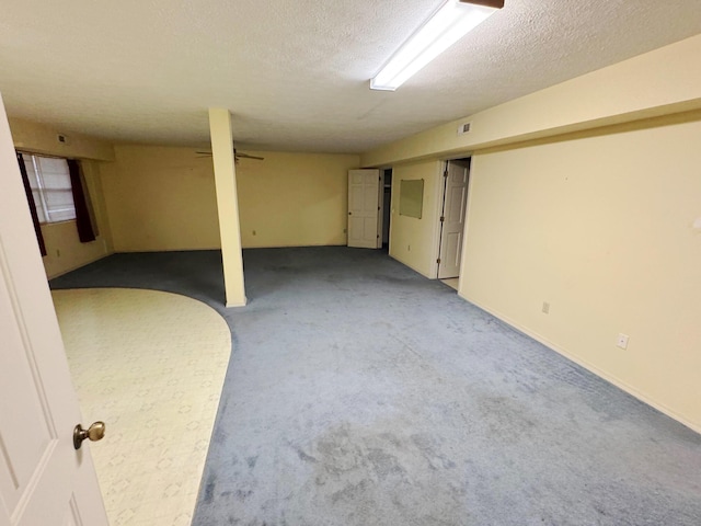 basement featuring a textured ceiling and carpet floors