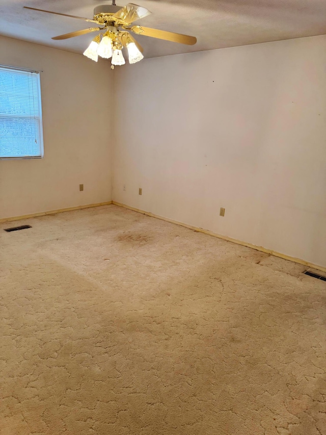 carpeted spare room featuring ceiling fan