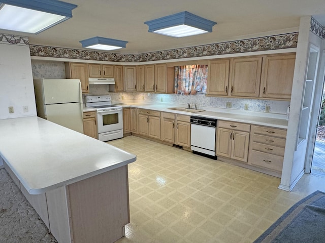 kitchen with kitchen peninsula, white appliances, and sink