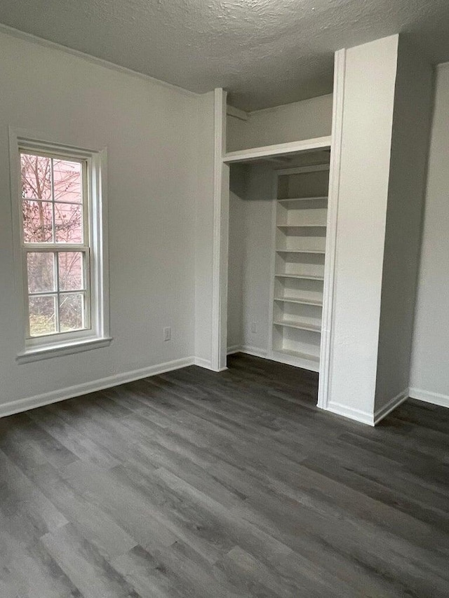 unfurnished bedroom with a closet, dark hardwood / wood-style flooring, and a textured ceiling