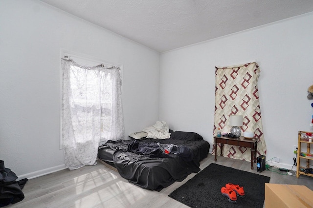 bedroom with hardwood / wood-style floors and a textured ceiling