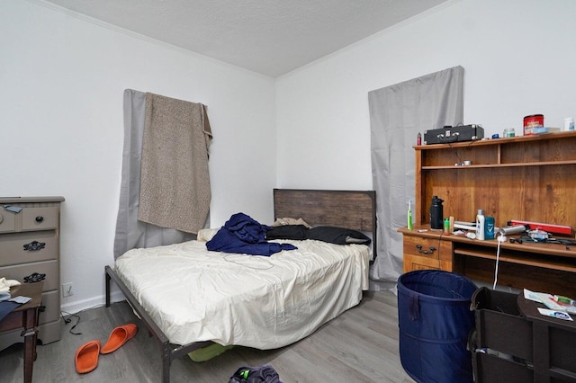 bedroom featuring crown molding and wood-type flooring