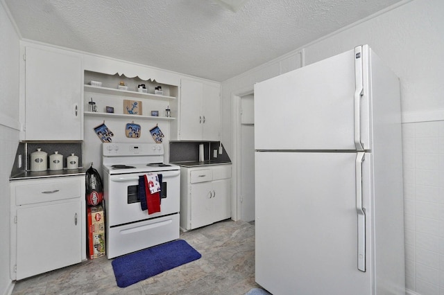 kitchen with stainless steel counters, white cabinetry, white appliances, and a textured ceiling