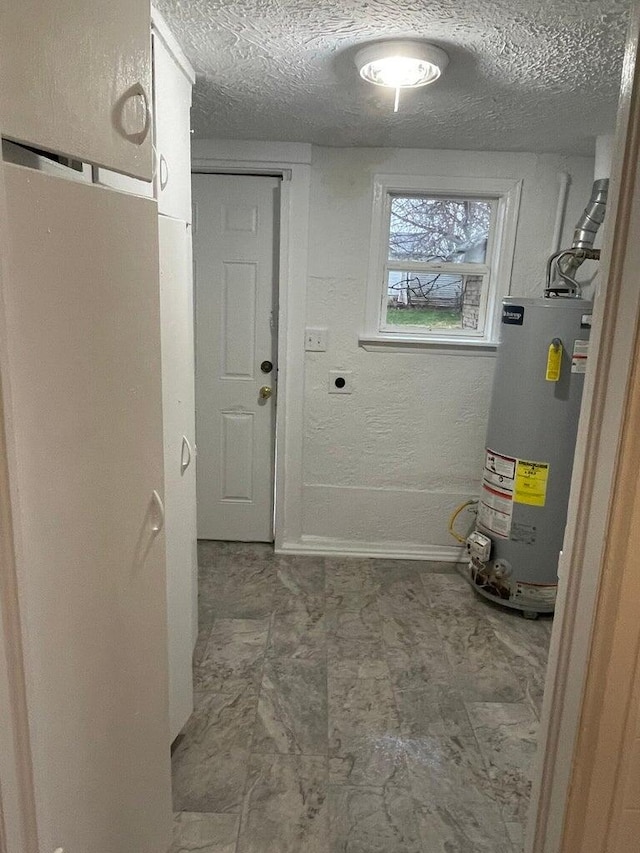 clothes washing area with water heater, a textured ceiling, and hookup for an electric dryer