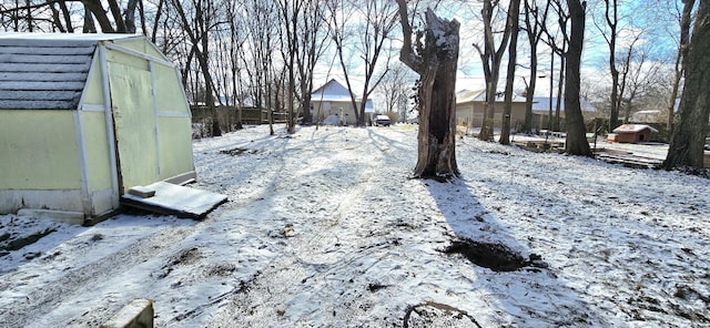 yard layered in snow with an outdoor structure