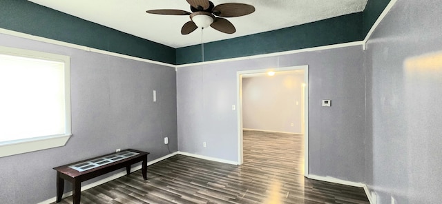 unfurnished room with ceiling fan and dark wood-type flooring