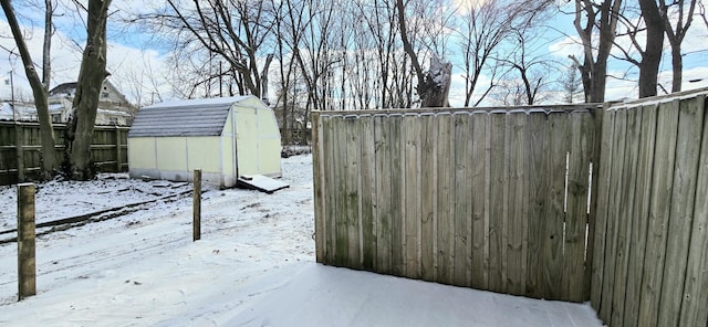 yard layered in snow with a storage unit