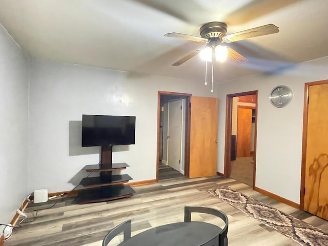 living room with light hardwood / wood-style flooring and ceiling fan