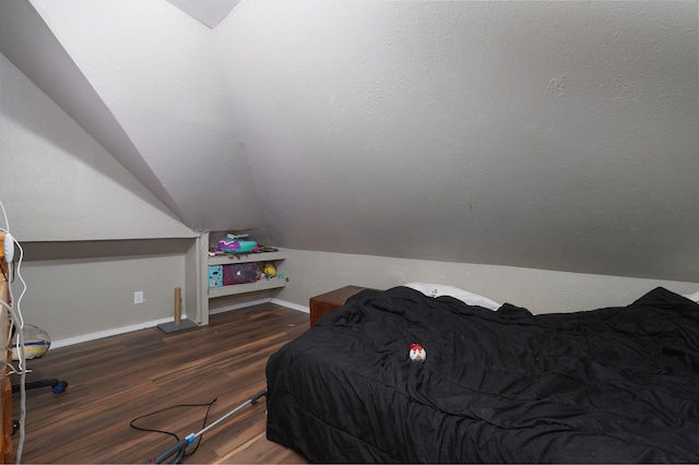 bedroom featuring dark hardwood / wood-style flooring and lofted ceiling