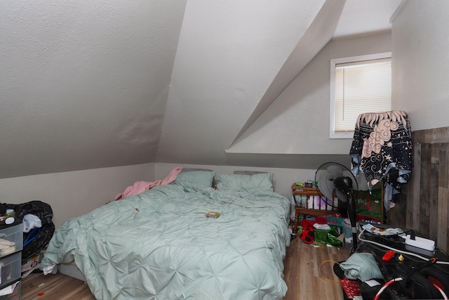 bedroom with hardwood / wood-style floors and vaulted ceiling