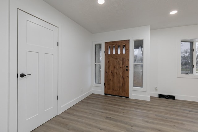 foyer featuring light hardwood / wood-style floors and a textured ceiling