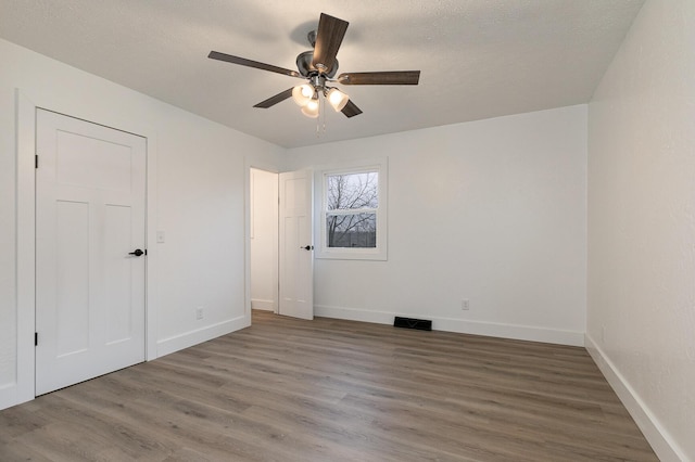 empty room featuring hardwood / wood-style floors and ceiling fan