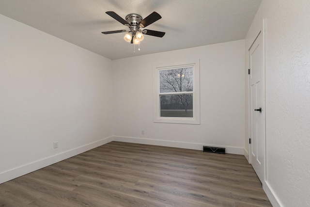 spare room with a textured ceiling, dark hardwood / wood-style flooring, and ceiling fan