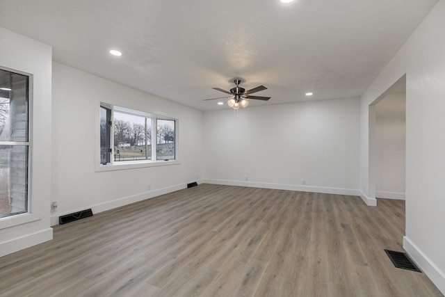 unfurnished room featuring ceiling fan, light hardwood / wood-style floors, and a textured ceiling