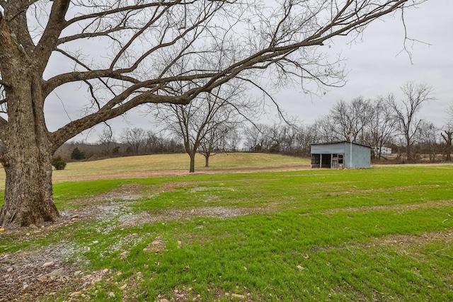 view of yard featuring a rural view and an outdoor structure