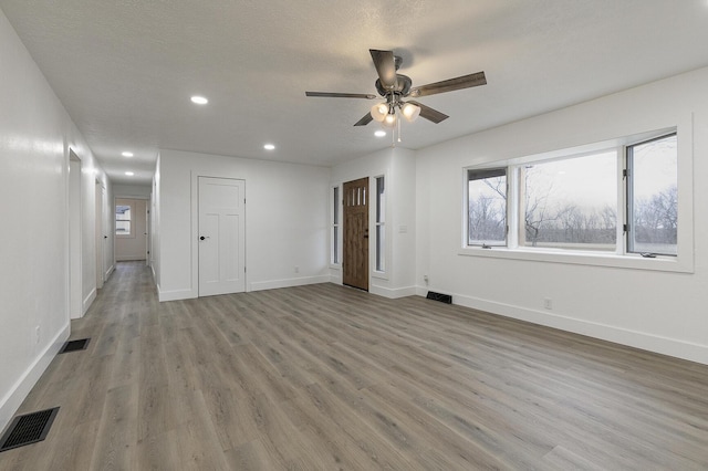 spare room featuring a textured ceiling, light hardwood / wood-style floors, and ceiling fan