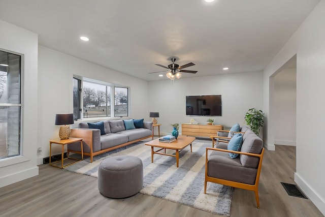 living room featuring wood-type flooring and ceiling fan