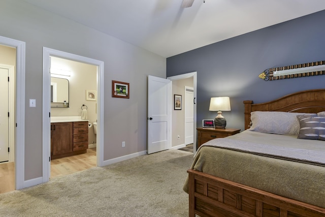 bedroom with ensuite bathroom, ceiling fan, and light colored carpet