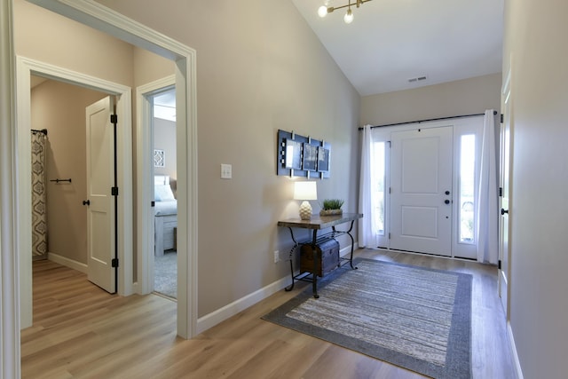 entrance foyer featuring vaulted ceiling, light hardwood / wood-style flooring, and a healthy amount of sunlight