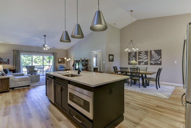 kitchen featuring a center island with sink, decorative light fixtures, sink, and ceiling fan with notable chandelier