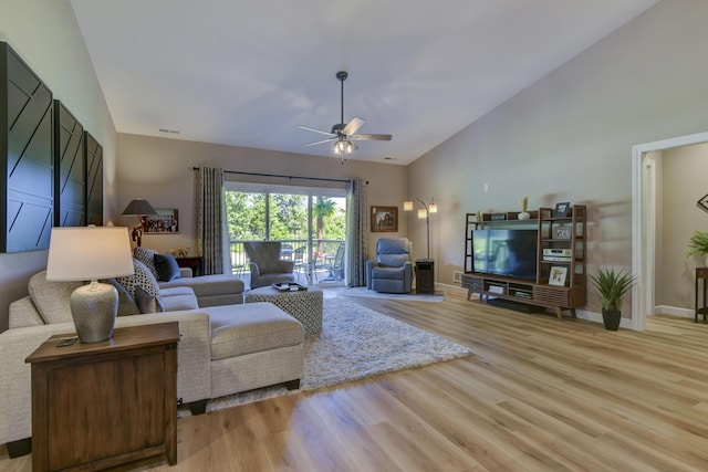 living room featuring vaulted ceiling, light hardwood / wood-style flooring, and ceiling fan