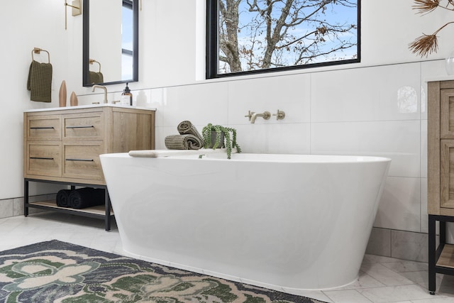 bathroom featuring a washtub, tile walls, and a healthy amount of sunlight