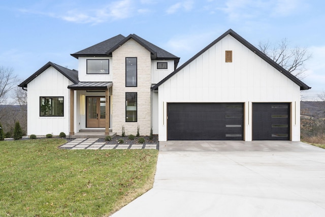 modern farmhouse style home featuring a garage, a front yard, and french doors